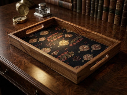 A rectangular wooden serving tray with cutout handles, featuring a dark navy blue fabric insert with a vintage-style botanical and medallion pattern in muted gold, red, and beige tones.